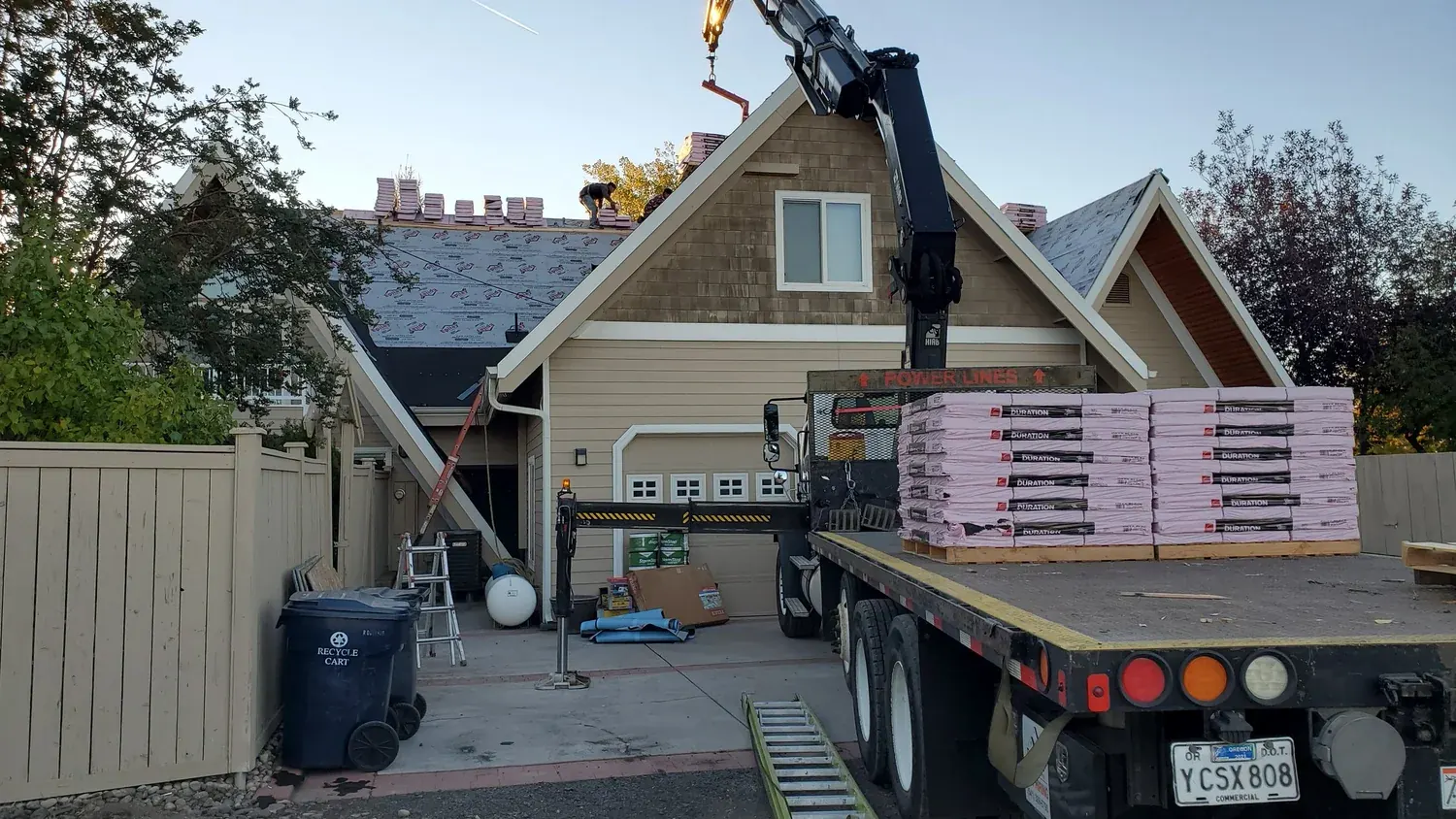Boom truck delivering shingle bundles to the roof