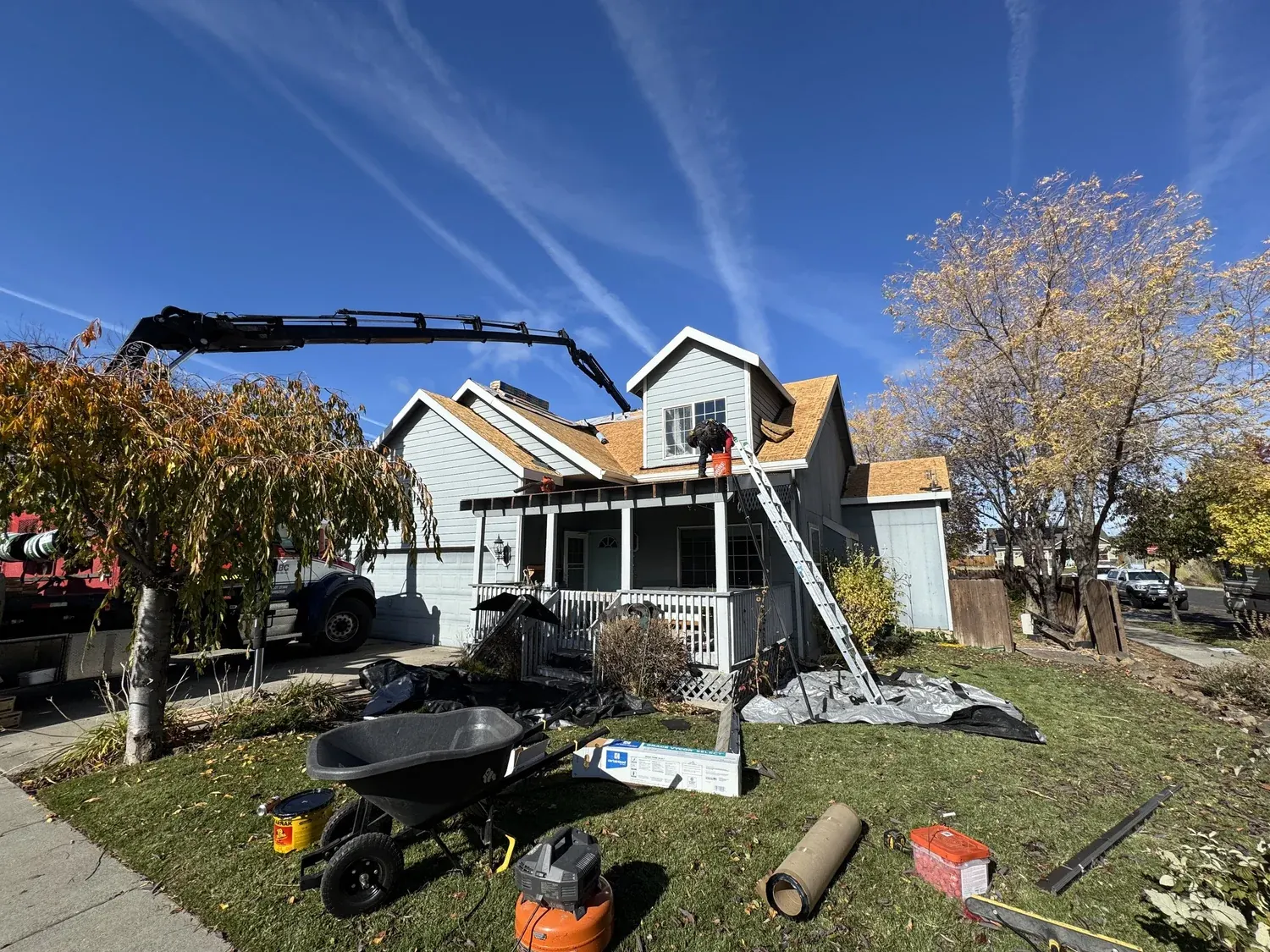 Boom truck staging materials at a two-story home